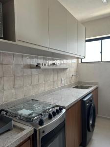 a kitchen with a stove and a sink in it at Graça Apartment in Salvador +12 photos