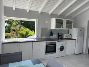 a kitchen with white appliances and a window at Bois patate location in Sainte-Anne