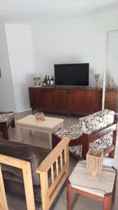 un soggiorno con mobili in legno e TV a schermo piatto di Casa LUA DEL PLATA con piscina exterior climatizada desde OCT hasta ABRIL a Parque del Plata