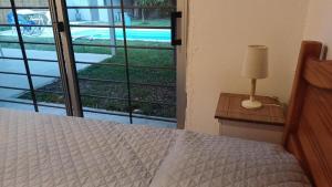 una camera da letto con un letto e una lampada su un tavolo di Casa LUA DEL PLATA con piscina exterior climatizada desde OCT hasta ABRIL a Parque del Plata Altre 8 foto