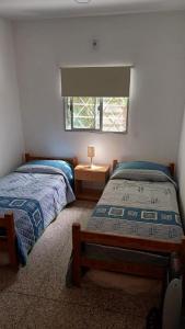 una camera da letto con due letti singoli e una finestra di Casa LUA DEL PLATA con piscina exterior climatizada desde OCT hasta ABRIL a Parque del Plata