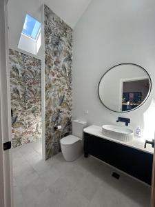 a bathroom with a sink and a mirror at Jezabel's Retreat Jervis Bay in Vincentia