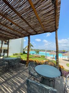 eine Terrasse mit Tischen und Stühlen und Blick auf den Strand in der Unterkunft Te Va a Encantar, Torre Turquesa in Mazatlán