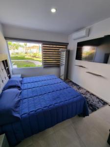 ein Schlafzimmer mit einem blauen Bett und einem großen Fenster in der Unterkunft Te Va a Encantar, Torre Turquesa in Mazatlán