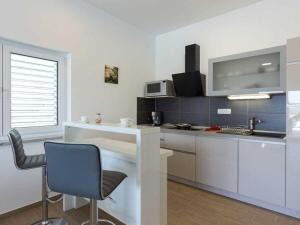 a kitchen with a counter and a chair in a room at Villa with sea view Comfortable holiday residence in Malinska