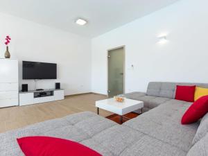 a living room with a couch and a tv at Villa with sea view Comfortable holiday residence in Malinska