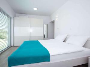 a bedroom with a large white bed with a blue blanket at Villa with sea view Comfortable holiday residence in Malinska +30 photos