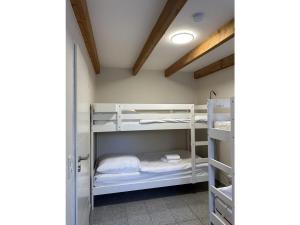 une chambre avec des lits superposés blancs dans une pièce dans l'établissement Holiday home Rennweide - MarBi all incl, à Dangast