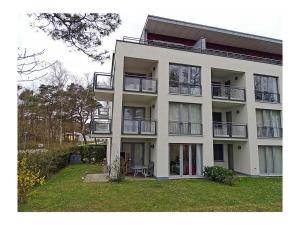 a large white building with balconies and a yard at Beach Dune Comfortable holiday residence in Juliusruh