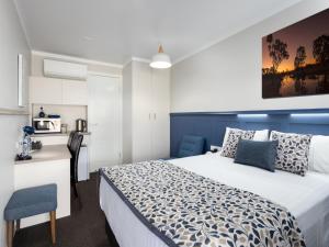 a hotel room with a bed and a desk and a chair at Granite Belt Motel in Stanthorpe