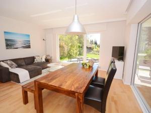 a living room with a wooden table and a couch at Summer house by the sea Comfortable holiday residence in Sierksdorf