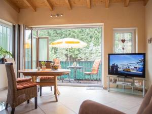 a living room with a television and a table with chairs at Haus Edelweiss Comfortable holiday residence in Winterberg