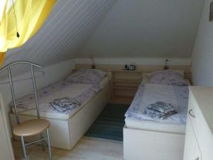 a room with two beds and a chair in a attic at Holiday apartment in Wiek with 1 room in Wiek auf Rügen 
