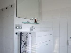 a white bathroom with a sink and a mirror at Holiday home with style Holiday apartment Rosenstraße links in Grömitz
