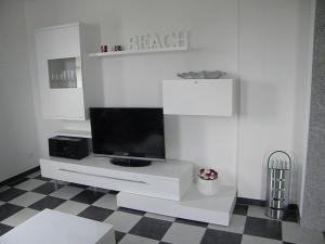 a living room with a tv on a white entertainment center at Modern Times Comfortable holiday spot in Zinnowitz