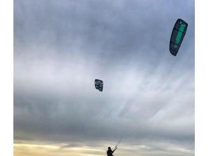 una persona sta facendo volare due aquiloni nel cielo di Sunrise with show kitchen on the IJsselmeer a Enkhuizen