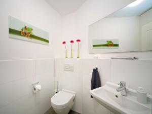 Un baño blanco con inodoro y lavabo. en Beach Castle "Beach Princess", en Binz