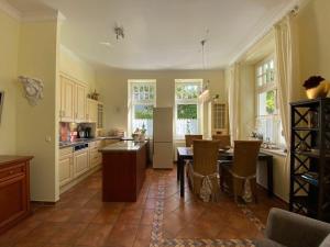 a large kitchen with a table and chairs in it at Palais am Park - App Luxembourg - Corner apartment No 1 in Kühlungsborn