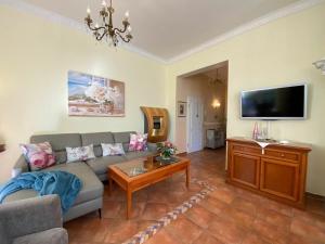 a living room with a couch and a tv at Palais am Park - App Luxembourg - Corner apartment No 1 in Kühlungsborn