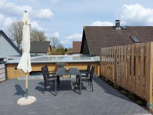 a patio with a table and chairs and an umbrella at Upper deck Comfortable holiday residence in Lindau