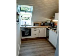 a small kitchen with white cabinets and a window at Upper deck Comfortable holiday residence in Lindau