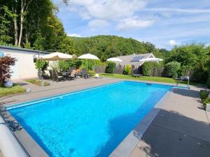 a swimming pool with blue water in a yard at Pension Sonnenberg Comfortable holiday residence in Silz