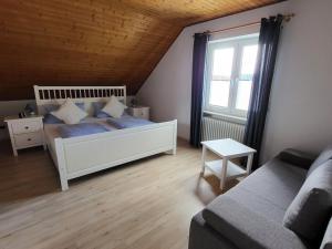 a bedroom with a bed and a couch and a window at Pension Sonnenberg Comfortable holiday residence in Silz +22 photos