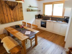 Il comprend une cuisine avec une table en bois et du parquet. dans l'établissement Heimatglück Comfortable holiday residence, à Lautenbach