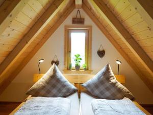 une chambre mansardée avec deux lits et une fenêtre dans l'établissement Heimatglück Comfortable holiday residence, à Lautenbach