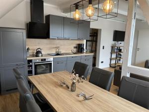 una cocina con una mesa de madera con sillas alrededor. en Small mountain house Comfortable holiday residence, en Braunlage 24 fotos más