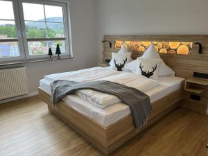 Un dormitorio con una cama grande con cabecero de madera. en Small mountain house Comfortable holiday residence, en Braunlage