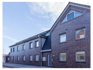 Un edificio de ladrillo rojo con ventanas a la calle. en Beach oasis Comfortable holiday residence, en Norddeich