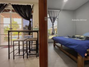 a bedroom with a bed and a table and a dining room at Diver Apartment in Panglao