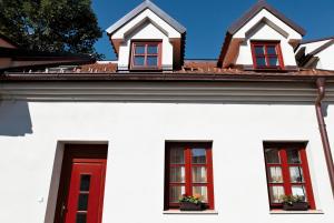 a white house with three windows and a red door at Apartment U Karla in Třeboň