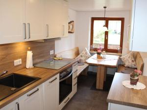 a kitchen with white cabinets and a table and a counter at on the Willmann farm in Erlenbach