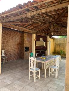 patio con tavolo e sedie sotto un tetto di Casa Refúgio de Jatobá - Barra dos Coqueiros a Barra dos Coqueiros