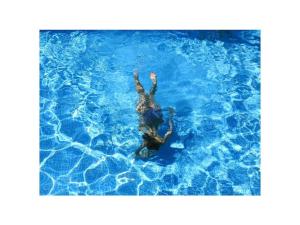 a person laying in a pool of blue water at Filmschip "Erbse" - buitengewoon woonboot op het land in Wiesentheid