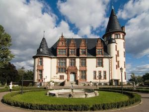 a large castle with a fountain in front of it at Mahlau 2 Ground floor Comfortable holiday residence in Waren