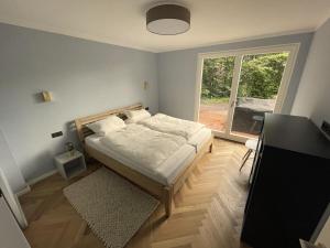a bedroom with a bed and a large window at Beach house Comfortable holiday residence in Glücksburg