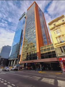 a tall building with glass windows on a city street at Apart Dos Naciones in Buenos Aires +7 photos
