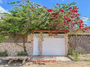a garage with a tree with flowers on top of it at Casa em Ilheus com Piscina Próxima a Praia in Ilhéus
