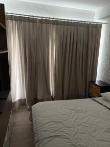 ein Schlafzimmer mit einem großen Bett und einem Vorhang in der Unterkunft Loft Moderno Manobrista e Equipado - 2 min Shoppings in São Paulo