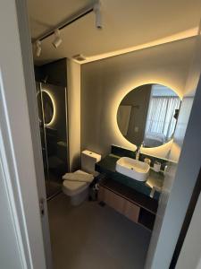 a bathroom with two toilets and a sink and a mirror at Loft Moderno - High Security And Garage Shoppings in Sao Paulo