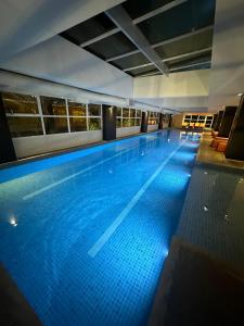 a large swimming pool with blue lighting in a building at Loft Moderno - High Security And Garage Shoppings in Sao Paulo