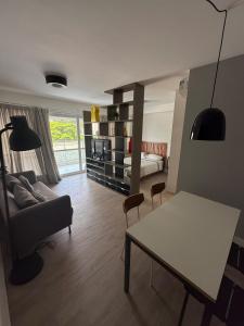 a living room with a couch and a table at Loft Moderno - High Security And Garage Shoppings in Sao Paulo