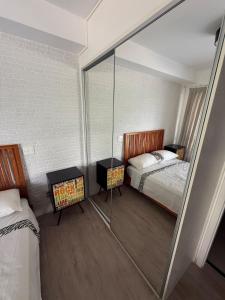 ein Schlafzimmer mit einem Bett und einer Glaswand in der Unterkunft Loft Moderno Manobrista e Equipado - 2 min Shoppings in São Paulo + 32 Fotos