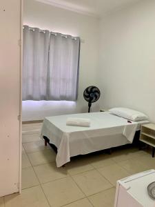 a white room with a bed and a window at Quarto Privativo ao lado do Aeroporto in Sao Jose do Rio Preto