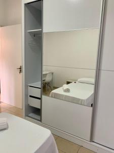 普雷图河畔圣若泽Quarto Privativo ao lado do Aeroporto的卧室内的镜子,配有床