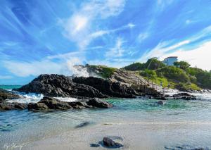 a beach with waves crashing on the rocks at Beach House Cabo Frio Hostel in Cabo Frio