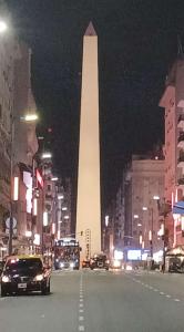 a large obelisk in the middle of a city at night at Apart Dos Naciones in Buenos Aires